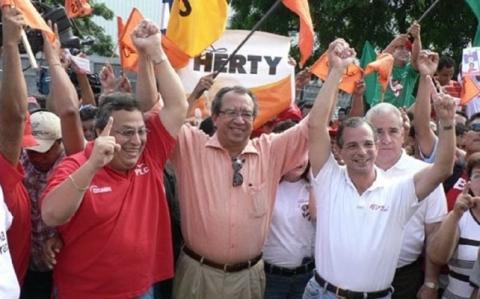Le banquier multimillionnaire de droite Eduardo Montealegre (à droite, en blanc) serrant la main du candidat présidentiel du MRS Edmundo Jarquín (au centre, en rose) et du politicien libéral Enrique Quiñónez (à gauche, en rouge), avec du matériel de campagne pour Herty Lewites en arrière-plan.